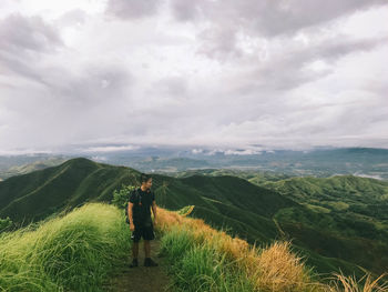 Man standing on mountain against sky