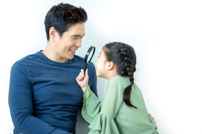 Young couple kissing against white background