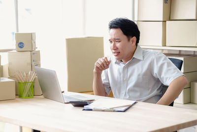 Man looking at camera while sitting on table