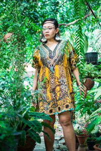 Portrait of woman standing against plants