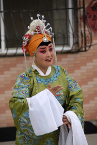 Young woman wearing traditional clothing standing outdoors