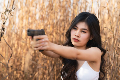 Portrait of woman photographing through smart phone