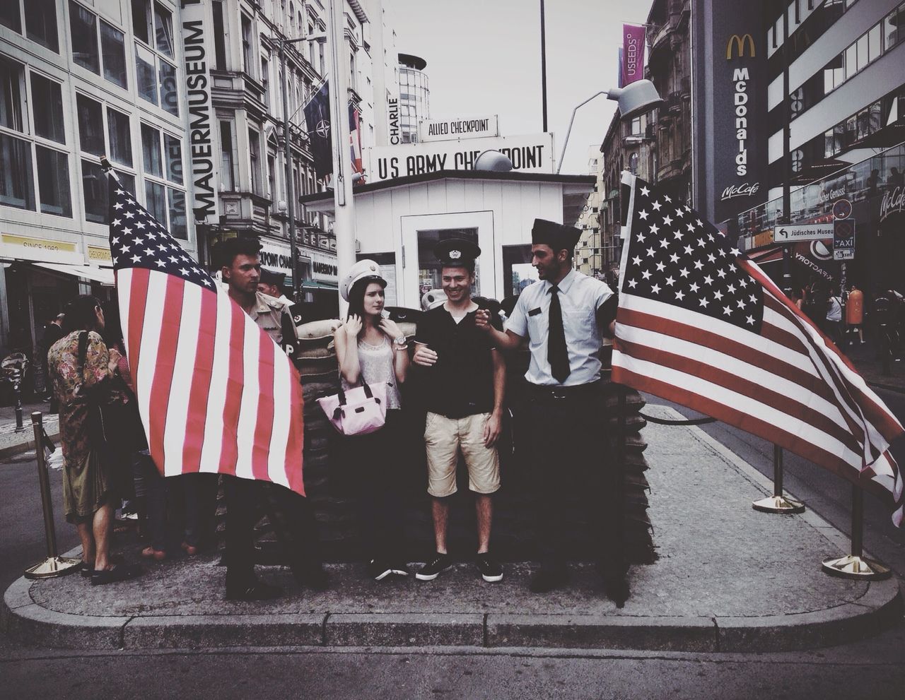 building exterior, architecture, built structure, city, street, men, person, flag, patriotism, city life, lifestyles, american flag, walking, national flag, transportation, identity, leisure activity, day, city street