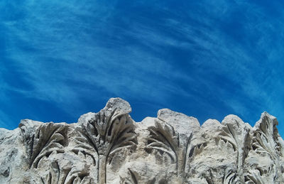 Low angle view of rocks against blue sky