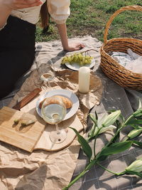 High angle view of woman standing by wicker basket on table