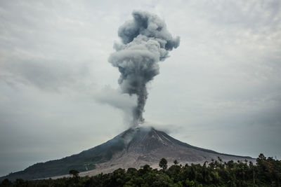 Smoke emitting from volcanic mountain against sky