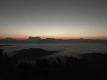 Scenic view of silhouette mountains against sky during sunset