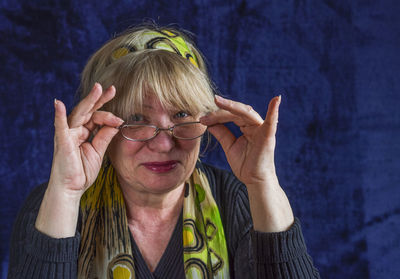Portrait of smiling mature woman against blue background