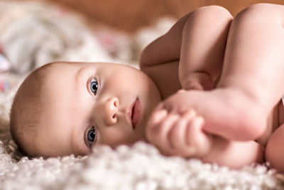 Portrait of baby lying on bed