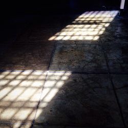 High angle view of sunlight falling on tiled floor
