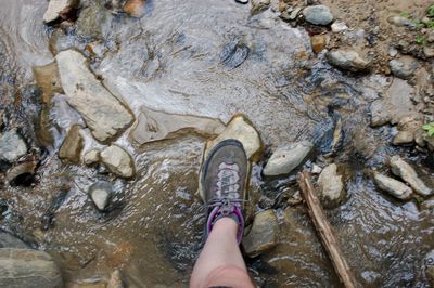 Close-up of hand on rock by river