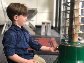 Side view of boy standing in kitchen