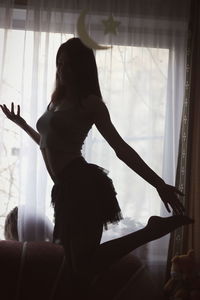 Woman dancing by window at home