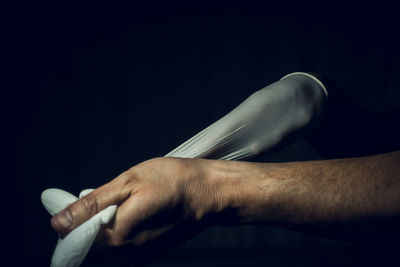 Close-up of man smoking cigarette against black background