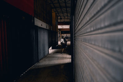 Man sitting in corridor of building