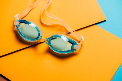 High angle view of paper with swimming goggles on table