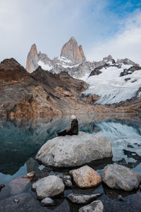 Woman sitting on a stone looking towards fitz roy