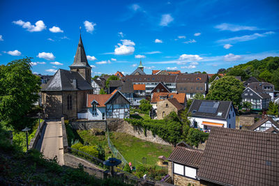 High angle view of buildings against blue sky