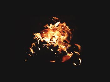 Low angle view of illuminated fire against black background