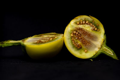 Close-up of fruits on table against black background