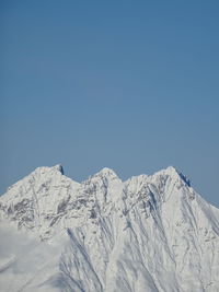 Snowcapped mountains against clear blue sky