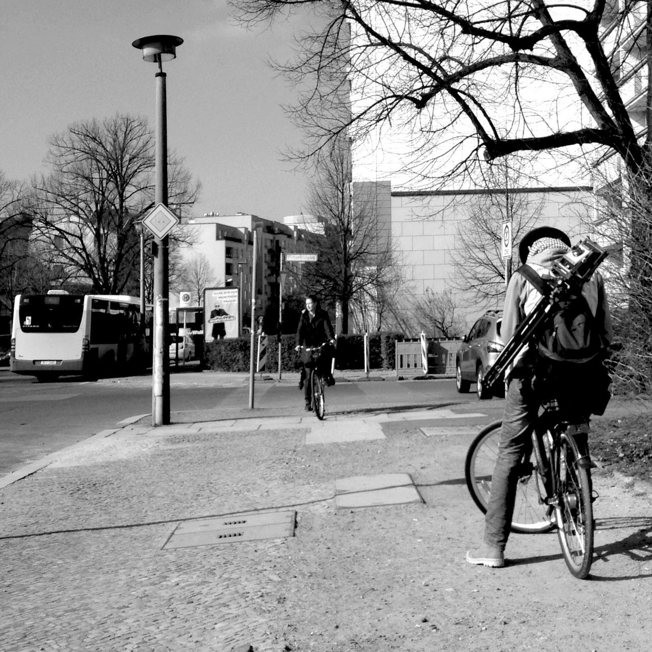 bicycle, transportation, street, building exterior, land vehicle, full length, tree, mode of transport, architecture, men, city, lifestyles, built structure, walking, road, riding, leisure activity, city life