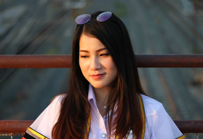 Beautiful woman looking away while standing by railing