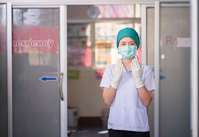 Portrait of woman standing in front of door