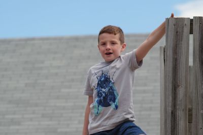 Portrait of boy standing at footpath