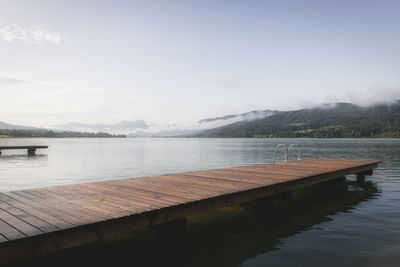 Pier on lake against sky