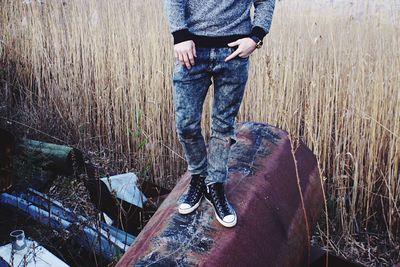 Low section of man standing on rusty pipe