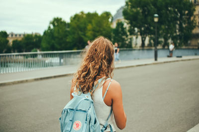 Rear view of woman standing on road