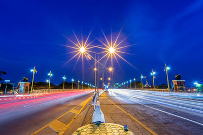 Light trails on road against sky at night