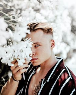 Portrait of young man with flower petals on snow