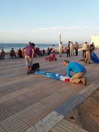 People at beach against sky