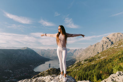 Woman standing on mountain against sky