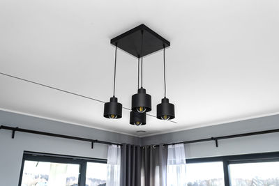 Modern chandeliers with tube shaped led bulbs, covered with matt black paint, four bulbs visible.
