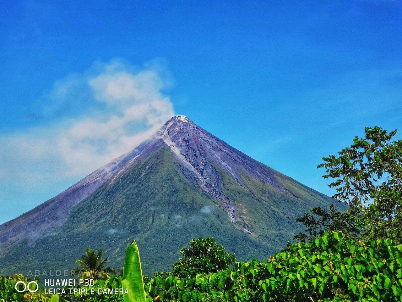 volcano, mountain, sky, plant, beauty in nature, stratovolcano, nature, volcanic landscape, landscape, scenics - nature, geology, no people, land, cloud, environment, travel destinations, volcanic crater, tree, non-urban scene, mountain peak, cinder cone, travel, blue, outdoors, active volcano, smoke, tourism, plateau, day, erupting, green, tranquil scene, plain, tranquility, culture