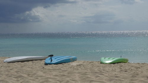 Surfboards on beach against sky