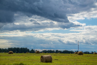 Hay bales on field against sky