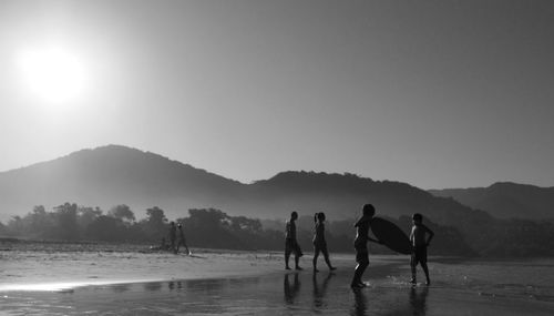 People enjoying on beach against sky