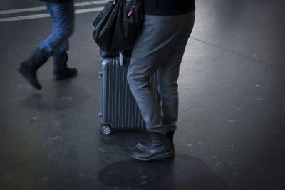 Low section of man standing on road