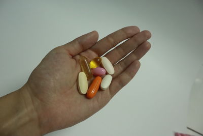 Close-up of man holding hands over white background