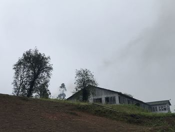 Low angle view of building and trees against sky