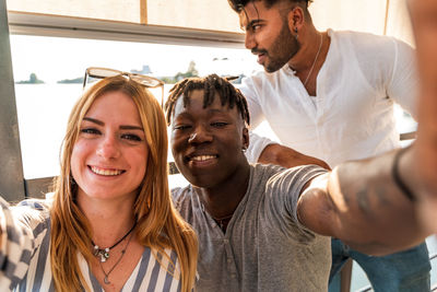 Portrait of smiling friends sitting at home