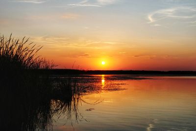 Scenic view of lake against orange sky