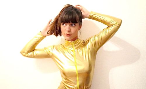 Portrait of young woman standing against white background