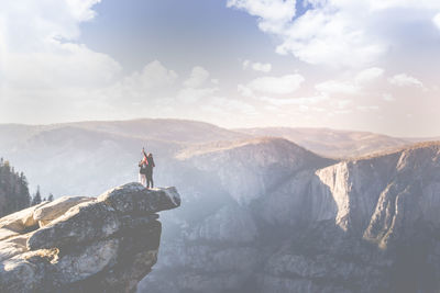 People standing on cliff against sky