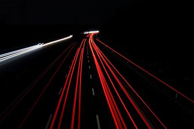 Light trails on road against sky at night