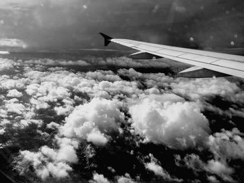 Airplane wing against cloudy sky